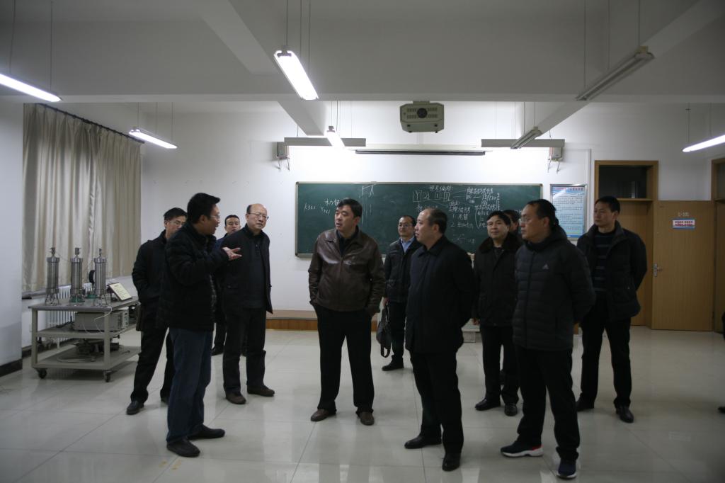 石油工程系副主任武世新(左二)向客人介绍情况